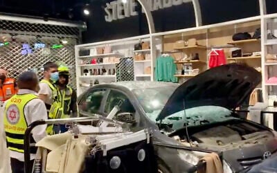 A car that crashed into a clothing store at a strip mall in the northern city of Kiryat Ata, October 23, 2021. (Screen capture: Twitter)