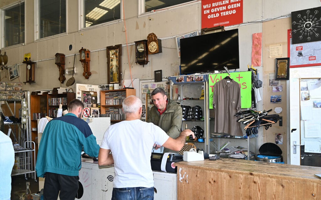 Gideon Italiaander listens to a customer at his shop in Amsterdam, the Netherlands on October 11, 2021. (Cnaan Liphshiz/ JTA)