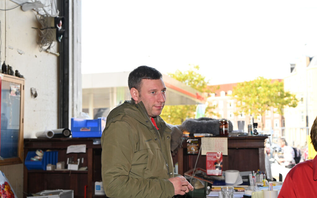 Gideon Italiaander listens to a customer at his shop in Amsterdam, the Netherlands on October 11, 2021. (Cnaan Liphshiz/ JTA)