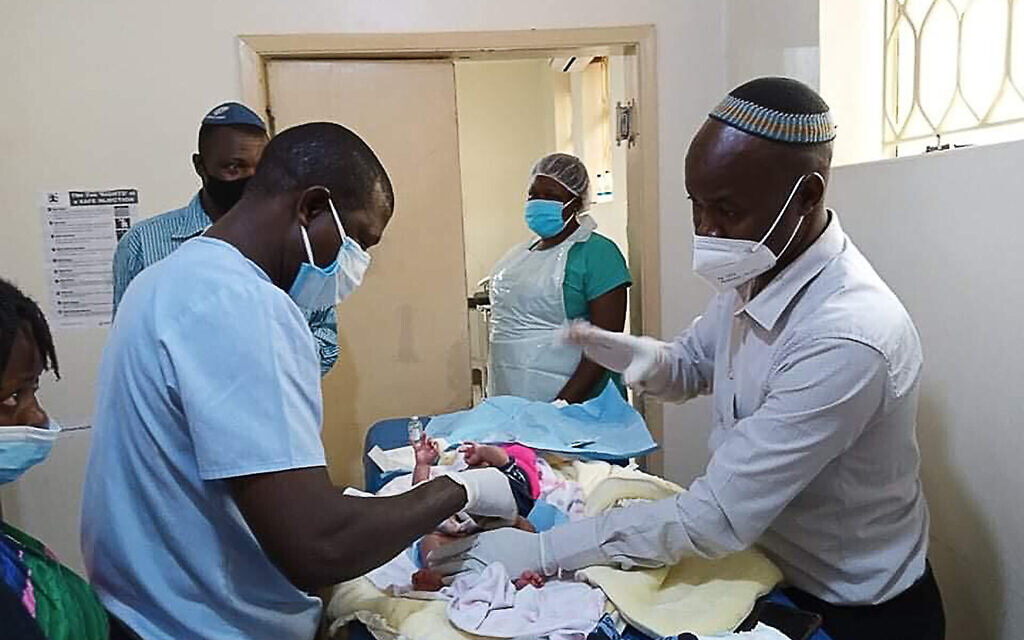Dr. Samson Wamani (right) serving as mohel, performs a traditional Jewish circumcision. (Courtesy of Wamani)