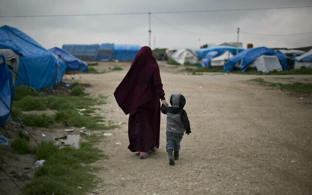 A foreign national married to an Islamic State member walks with their son at Camp Roj in north Syria, March 27, 2019. (Maya Alleruzzo/AP) A foreign national married to an Islamic State member walks with their son at Camp Roj in north Syria, March 27, 2019. (Maya Alleruzzo/AP)