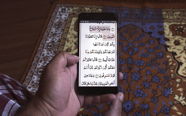 Illustrative -- In this April 25, 2020, photo, a man reads the holy Quran on his phone during the first day of Ramadan in Mumbai, India (AP Photo/Rafiq Maqbool) Illustrative -- In this April 25, 2020, photo, a man reads the holy Quran on his phone during the first day of Ramadan in Mumbai, India (AP Photo/Rafiq Maqbool)