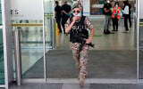 Illustrative: A female police officer adjust her mask as she guards at Cyprus' main airport in Larnaca, on June 9, 2020. (AP Photo/Petros Karadjias)