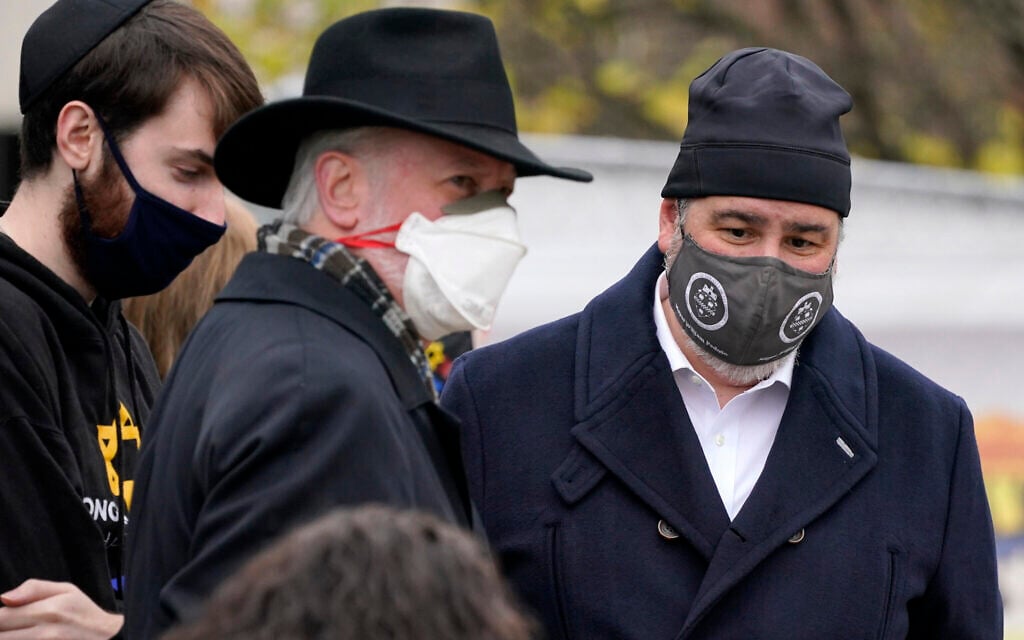 Rabbi Jeffrey Myers, center, his son Aaron, left, and Pittsburgh Mayor Bill Peduto gather outside the Tree of Life synagogue in Pittsburgh for a moment of silence on October 27, 2020, the second anniversary of the shooting at the synagogue, that killed 11 worshipers. (AP Photo/Gene J. Puskar)