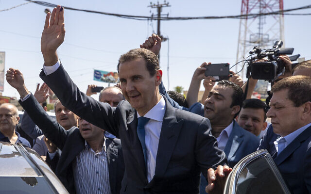 In this May 26, 2021 file photo, Syrian President Bashar Assad, center, waves to his supporters at a polling station during the Presidential elections in Douma, Syria. (AP Photo/Hassan Ammar) In this May 26, 2021 file photo, Syrian President Bashar Assad, center, waves to his supporters at a polling station during the Presidential elections in Douma, Syria. (AP Photo/Hassan Ammar)