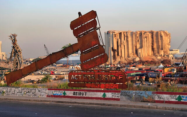 In this Aug. 4, 2021 file photo, a monument that represents justice stands in front of towering grain silos that were gutted in the massive August 2020 explosion at the port in Beirut, Lebanon (AP Photo/Hussein Malla, File) In this Aug. 4, 2021 file photo, a monument that represents justice stands in front of towering grain silos that were gutted in the massive August 2020 explosion at the port in Beirut, Lebanon (AP Photo/Hussein Malla, File)