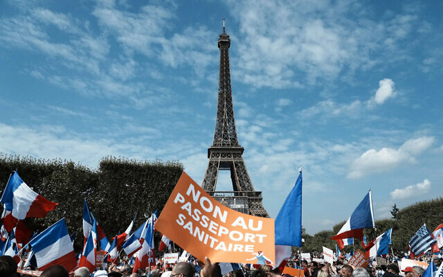 In this September 4, 2021, file photo, a protester holds a placard reading "No to the health pass" during a demonstration against the COVID-19 health pass in front of the Eiffel Tower, in Paris. (AP Photo/Thibault Camus, File) In this September 4, 2021, file photo, a protester holds a placard reading "No to the health pass" during a demonstration against the COVID-19 health pass in front of the Eiffel Tower, in Paris. (AP Photo/Thibault Camus, File)