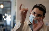 A medical worker prepares a vial of the Pfizer coronavirus vaccine at Clalit Health Service's vaccination center in the Cinema City complex in Jerusalem, September 22, 2021. (AP Photo/Maya Alleruzzo)