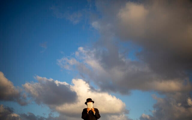 An ultra-Orthodox Jewish man of the Kiryat Sanz Hasidic sect prays on a hill overlooking the Mediterranean Sea as they participate in a Tashlich ceremony, in Netanya, Israel, on Tuesday, Sept. 14, 2021. (AP Photo/Ariel Schalit)