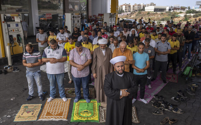 Muslim worshippers pray during Friday prayers at a gas station to protest severe fuel shortages that Lebanon has been witnessing for weeks, in the coastal town of Jiyeh, south of Beirut, Lebanon, on Friday, September 3, 2021. (AP Photo/Hassan Ammar)