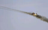 In this undated picture released by the official website of the Iranian Army on October 1, 2021, a helicopter fires in a maneuver near Iranian border with Azerbaijan. (Iranian Army via AP)