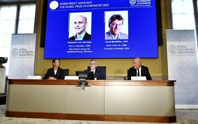 Goran K Hansson, Permanent Secretary of the Royal Swedish Academy of Sciences, centre, announces the winners of the 2021 Nobel Prize in Chemistry, in Stockholm, Sweden, October 6, 2021. (Claudio Bresciani/TT New Agency via AP)