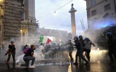Demonstrators and police clash during a protest, in Rome, October 9, 2021. (Mauro Scrobogna/LaPresse via AP)