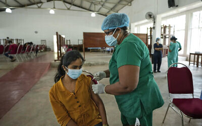 A Sri Lankan university student receives her coronavirus vaccine at the Sri Jayawardenapura university in Colombo, Sri Lanka, October 11, 2021. (Eranga Jayawardena/AP)