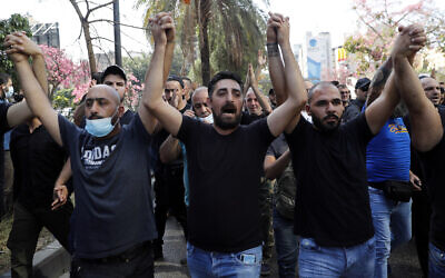 Supporters of the Shiite Hezbollah and Amal groups chant slogans against Judge Tarek Bitar who is investigating last year's deadly seaport blast, during a protest in front of the Justice Palace in Beirut, Lebanon, on Thursday, October 14, 2021. (AP Photo/Hussein Malla)