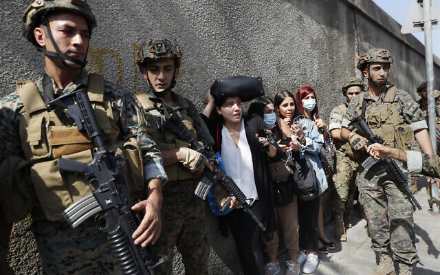 Lebanese teachers react to the sounds from nearby armed clashes as they flee their school under the protection of Lebanese soldiers after a clashes erupted along a former 1975-90 civil war front-line between Muslim Shiite and Christian areas at Ain el-Remaneh neighborhood, in Beirut, Lebanon, on October 14, 2021. (AP Photo/Hussein Malla) Lebanese teachers react to the sounds from nearby armed clashes as they flee their school under the protection of Lebanese soldiers after a clashes erupted along a former 1975-90 civil war front-line between Muslim Shiite and Christian areas at Ain el-Remaneh neighborhood, in Beirut, Lebanon, on October 14, 2021. (AP Photo/Hussein Malla)