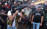 Supporters of the Shi'ite Amal group fire weapons in the air during the funeral processions of Hassan Jamil Nehmeh, who was killed during yesterday clashes, in the southern Beirut suburb of Dahiyeh, Lebanon, on Friday, October 15, 2021. (AP/Bilal Hussein)