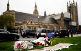 Flowers are placed as a tribute in Parliament Square following Friday's death of member of Parliament David Amess in Leigh-on-Sea, Essex, in London, on October 16, 2021. (Aaron Chown/PA via AP)