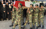 Volunteers from the Baath battalions carry the Syrian flag-wrapped coffin of Midhat as-Saleh, allegedly shot by Israeli sniper fire, in Ain Eltinah, a village along the Israeli border in the Golan Heights, during his funeral procession in Jaramana, southeast of Damascus, Syria, October 18, 2021. (AP Photo)