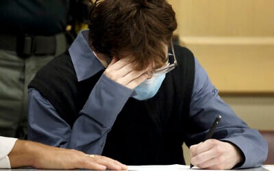Marjory Stoneman Douglas High School shooter Nikolas Cruz signs a document while seated at the defense table as he is in court to plead guilty to all 17 counts of premeditated murder and 17 counts of attempted murder in the 2018 shootings, October 20, 2021, at the Broward County Courthouse in Fort Lauderdale, Florida. (Amy Beth Bennett/South Florida Sun Sentinel via AP, Pool)