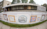 This photo from Oct. 16, 2021, shows the dormant landmark Tree of Life synagogue with the fencing showing artwork submitted by Pittsburgh area school students in Pittsburgh's Squirrel Hill neighborhood. (AP Photo/Keith Srakocic)