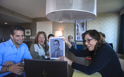 Anna Salton Eisen holds up a photo of Emil Ringel, father of Barbara Ringel, for a Zoom video call during a gathering for families of Holocaust survivors in East Brunswick, NJ, on September 26, 2021. (AP Photo/Brittainy Newman)