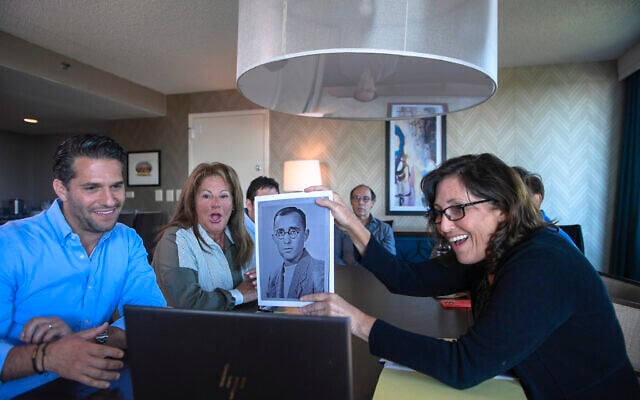 Anna Salton Eisen holds up a photo of Emil Ringel, father of Barbara Ringel, for a Zoom video call during a gathering for families of Holocaust survivors in East Brunswick, NJ, on September 26, 2021. (AP Photo/Brittainy Newman)