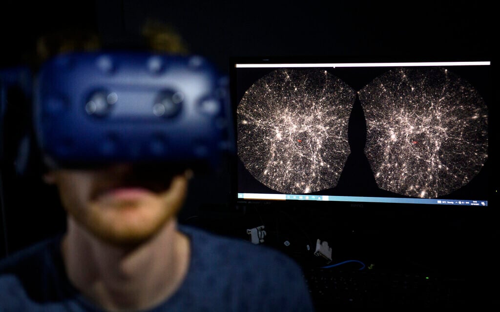 In this Oct. 12, 2021 file photo, Hadrien Gurnel, software engineer at EPFL's Laboratory for Experimental Museology (eM+) explores with a virtual reality helmet the most detailed 3D map of the universe with the virtual reality software VIRUP, Virtual Reality Universe Project developed by Swiss Federal Institute of Technology, in St-Sulpice near Lausanne, Switzerland. (Laurent Gillieron/Keystone via AP) In this Oct. 12, 2021 file photo, Hadrien Gurnel, software engineer at EPFL's Laboratory for Experimental Museology (eM+) explores with a virtual reality helmet the most detailed 3D map of the universe with the virtual reality software VIRUP, Virtual Reality Universe Project developed by Swiss Federal Institute of Technology, in St-Sulpice near Lausanne, Switzerland. (Laurent Gillieron/Keystone via AP)