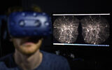 In this Oct. 12, 2021 file photo, Hadrien Gurnel, software engineer at EPFL's Laboratory for Experimental Museology (eM+) explores with a virtual reality helmet the most detailed 3D map of the universe with the virtual reality software VIRUP, Virtual Reality Universe Project developed by Swiss Federal Institute of Technology, in St-Sulpice near Lausanne, Switzerland.  (Laurent Gillieron/Keystone via AP)
