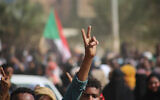 Pro-democracy protesters flash the victory sign as they take to the streets to condemn a takeover by military officials, in Khartoum, Sudan, October 25, 2021. (Ashraf Idris/AP)