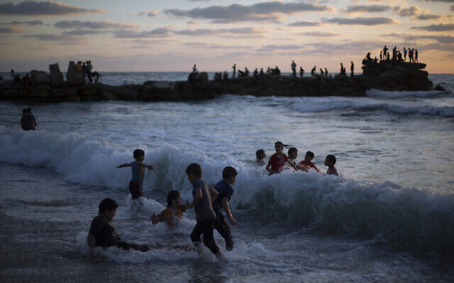 Palestinian children play in the water as the sun sets over the beach of Gaza City,  June 4, 2021. (AP Photo/Khalil Hamra)