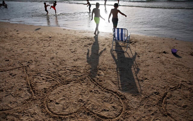 Heart shapes drawn in sand as the sun sets over Tel Aviv's beach, Israel, June 12, 2021. (AP Photo/Oded Balilty)