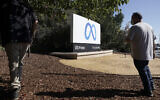 Facebook employees take a photo in front of new Meta Platforms Inc. sign outside the company headquarters in Menlo Park, Calif., Thursday, Oct. 28, 2021. .(AP Photo/Tony Avelar)