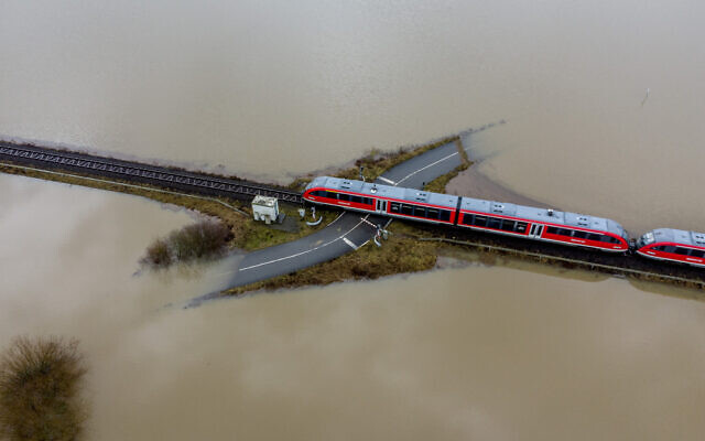 A train passes a railroad crossing surrounded by floodwaters from rain and melting snow in Nidderau near Frankfurt, Germany, on February 3, 2021. (AP Photo/Michael Probst) A train passes a railroad crossing surrounded by floodwaters from rain and melting snow in Nidderau near Frankfurt, Germany, on February 3, 2021. (AP Photo/Michael Probst)