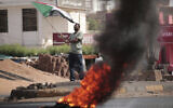 A man waves the Sudanese national flag as he chants slogans during a protest in Khartoum, Sudan, on October 30, 2021. (AP Photo/Marwan Ali)