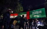 Lebanese men hold banner displaying the flags of Saudi Arabia, the United Arab Emirates, and Egypt, during a protest in support of the kingdom against comments made by a Lebanese minister over the war in Yemen, in front of the Saudi Arabia Embassy in Beirut, Lebanon, on October 30, 2021. (AP Photo/ Bilal Hussein)