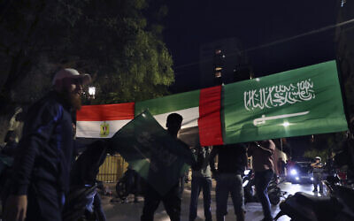 Lebanese men hold banner displaying the flags of Saudi Arabia, the United Arab Emirates, and Egypt, during a protest in support of the kingdom against comments made by a Lebanese minister over the war in Yemen, in front of the Saudi Arabia Embassy in Beirut, Lebanon, on October 30, 2021. (AP Photo/ Bilal Hussein)