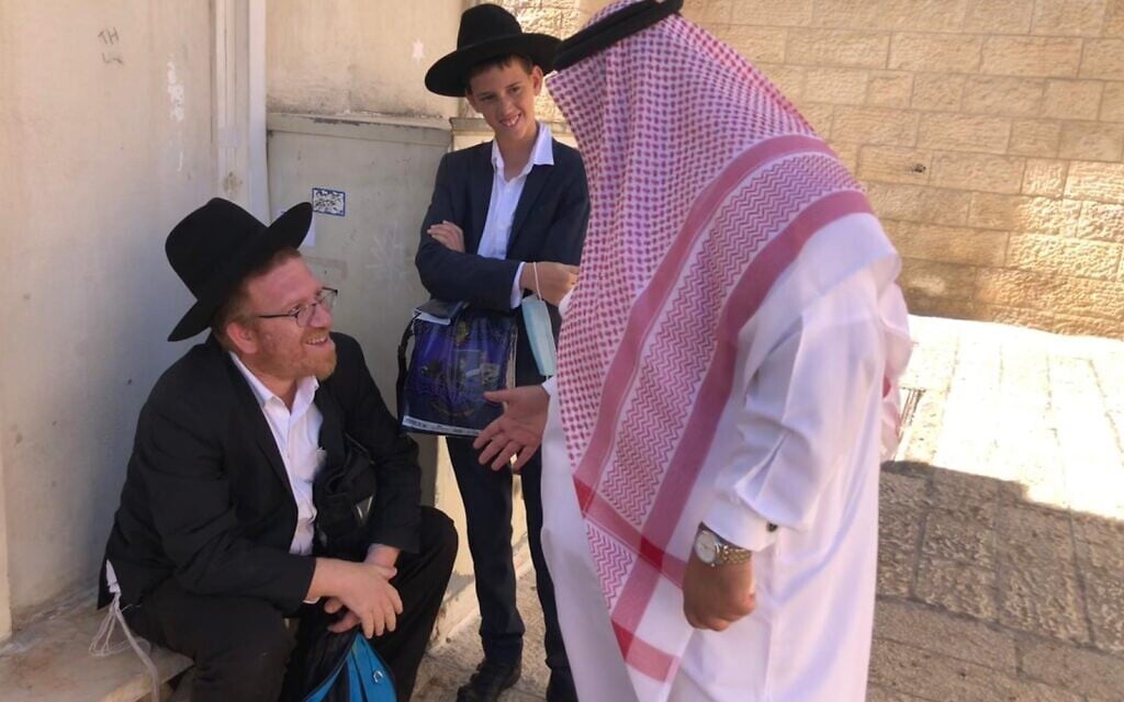 Bahraini education official Mohammed Saleh speaks to a Haredi father and son in the Old City of Jerusalem, October 6, 2021 (Lazar Berman, Times of Israel)
