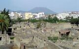 Ancient Herculaneum is seen on a backdrop of modern Ercolano and Vesuvius (CC BY-SA Qfl247/ Wikimedia Commons)