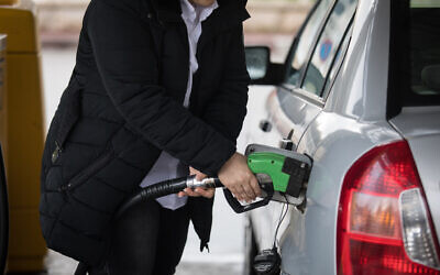 Illustrative: A woman fills her car's gas tank, at a gas station in Jerusalem, on March 31, 2019. (Hadas Parush/Flash90)