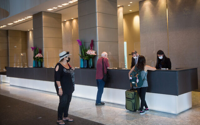 Guests at the reception desk in a Tel Aviv hotel, April 27, 2021. (Miriam Alster/ FLASH90)
