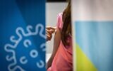 Illustrative: A young girl receives a COVID-19 vaccine at a temporary Clalit Health Services facility in Jerusalem, August 15, 2021. (Yonatan Sindel/Flash90)
