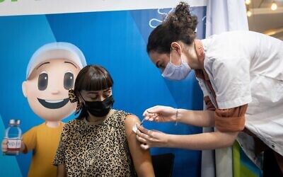 A woman receives a dose of the COVID-19 vaccine in Jerusalem, September 30, 2021 (Yonatan Sindel/Flash90)