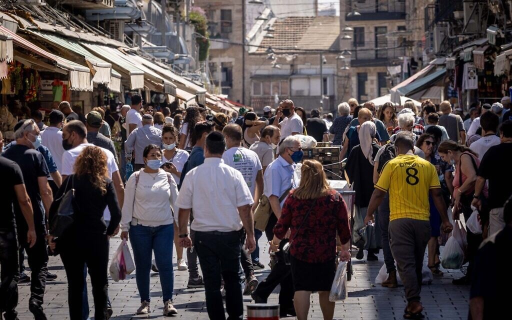 Israelis, some wearing face masks, shop at the Mahane Yehuda market in Jerusalem on October 5, 2021. (Yonatan Sindel/Flash90)