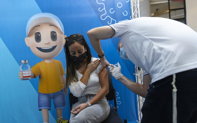 People receive a dose of the COVID-19 vaccine at a health clinic, in Jerusalem, on October 7, 2021. (Olivier Fitoussi/Flash90) People receive a dose of the COVID-19 vaccine at a health clinic, in Jerusalem, on October 7, 2021. (Olivier Fitoussi/Flash90)