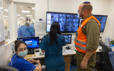 Shaare Zedek hospital staff and an IDF soldier gathered around computer screens on October 14, 2021. (Olivier Fitoussi/Flash90) Shaare Zedek hospital staff and an IDF soldier gathered around computer screens on October 14, 2021. (Olivier Fitoussi/Flash90)