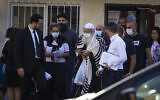 One of the men arrested on suspicion of murdering Avraham Edri and Nissim Shitrit is brought for a court hearing outside the Jerusalem Magistrate's Court on October 17, 2021. (Olivier Fitoussil/Flash90)