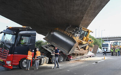 Police at the scene where a truck transporting a bulldozer hit a bridge on October 26, 2021 (Flash90)