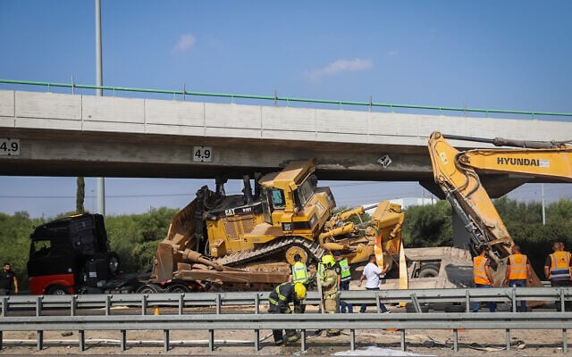 Police at the scene where a truck transporting a bulldozer struck an overpass on Route 1, at the Ben Gurion interchange, on October 26, 2021. (Yossi Aloni/Flash90) Police at the scene where a truck transporting a bulldozer struck an overpass on Route 1, at the Ben Gurion interchange, on October 26, 2021. (Yossi Aloni/Flash90)