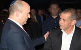 Prime Minister Naftali Bennett (L) greets outgoing Shin Bet head Nadav Argaman  at an event to honor the departing security chief on October 14, 2021 (Amos Ben Gershom/GPO)